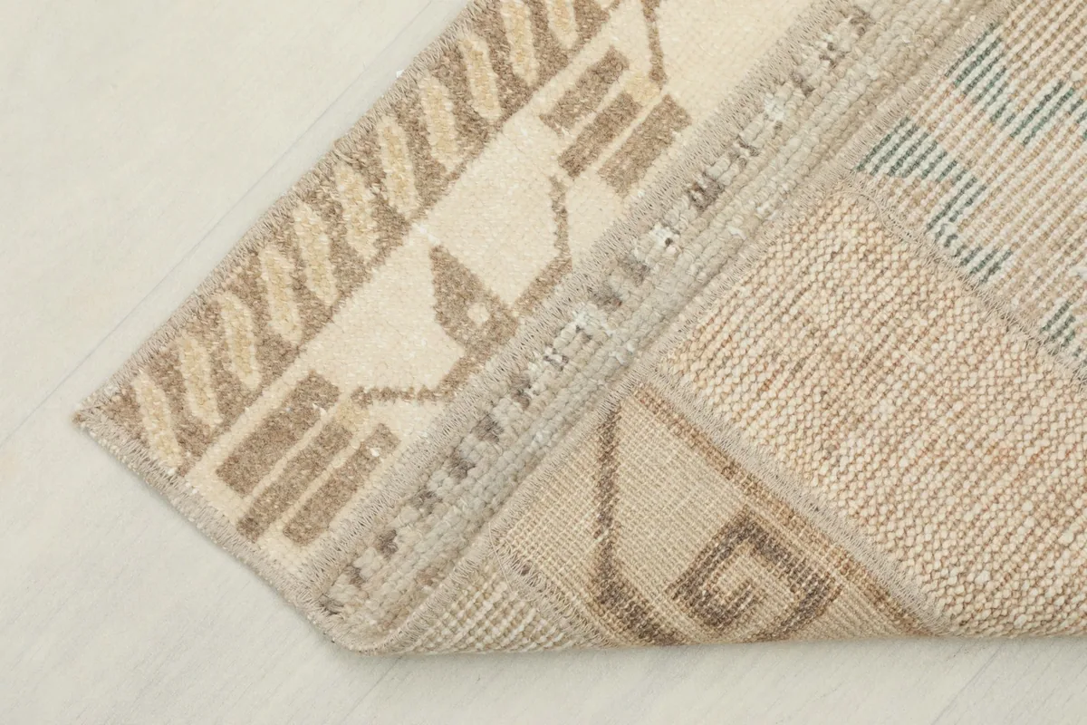 View of the back of the hand-knotted rug, showing the cotton foundation and construction.