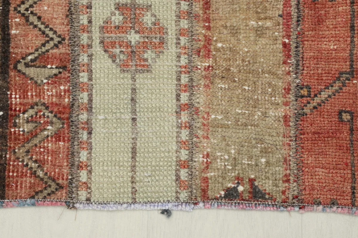 Detail of the short fringes and the edge finishing of the vintage hand-knotted rug.