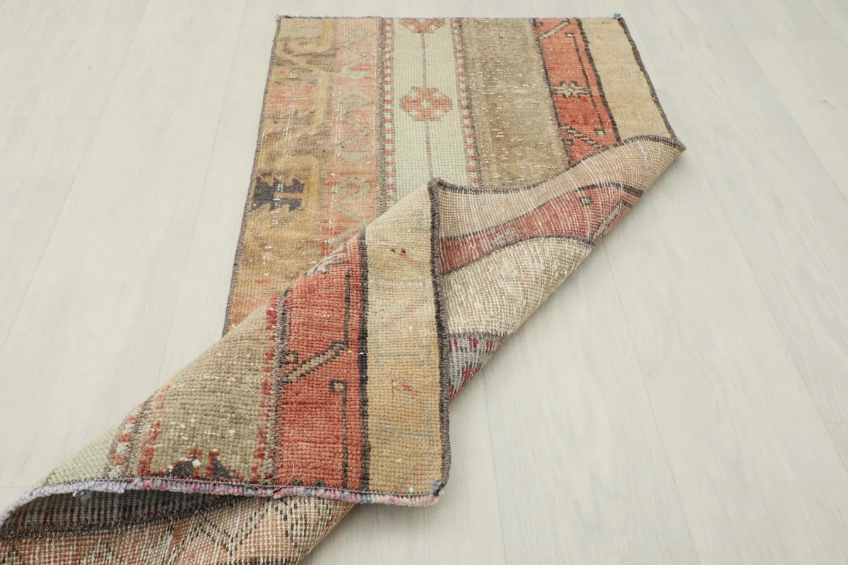 The rug partially folded, showing the flexibility and thickness of the wool pile on cotton foundation.