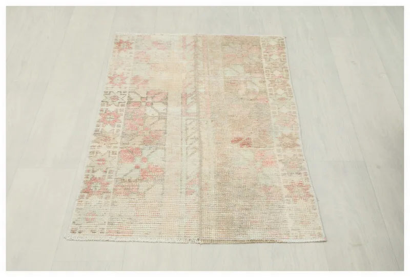 Full overhead view of the beige and rose vintage Anatolian rug on a white background.
