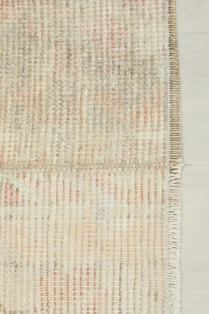 Close-up of the side edge of the rug, showing the intact selvage and fringe detail.