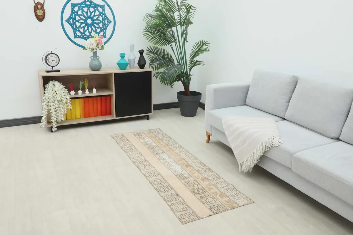 Beige striped runner rug placed in a modern living room setting with a light grey sofa.