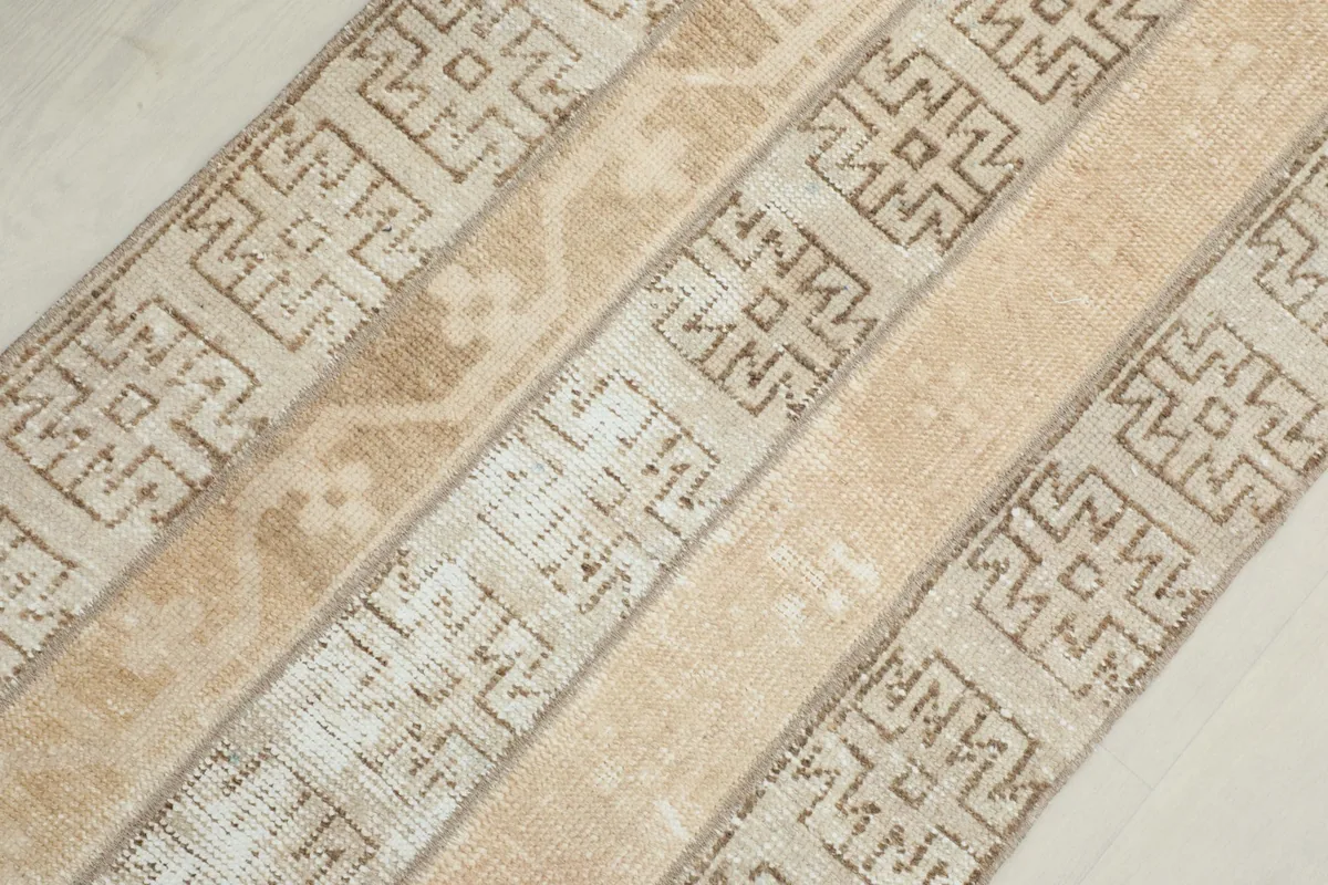 Diagonal overhead shot capturing the striped design and the different geometric motifs across the rug.