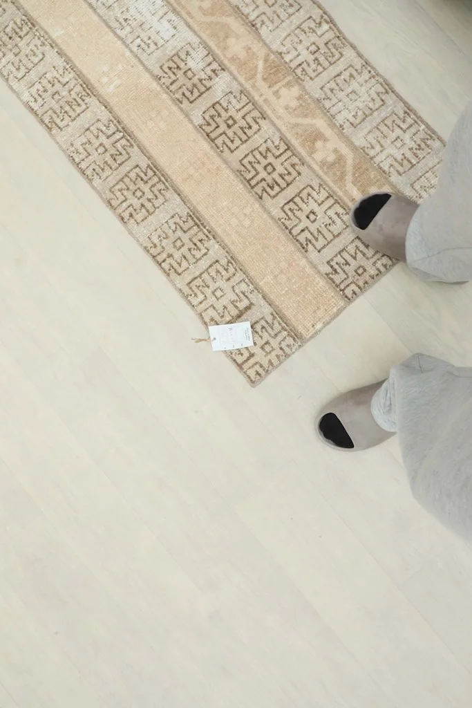 Overhead view of the runner on the floor with feet for scale, showing the rug's size in context.