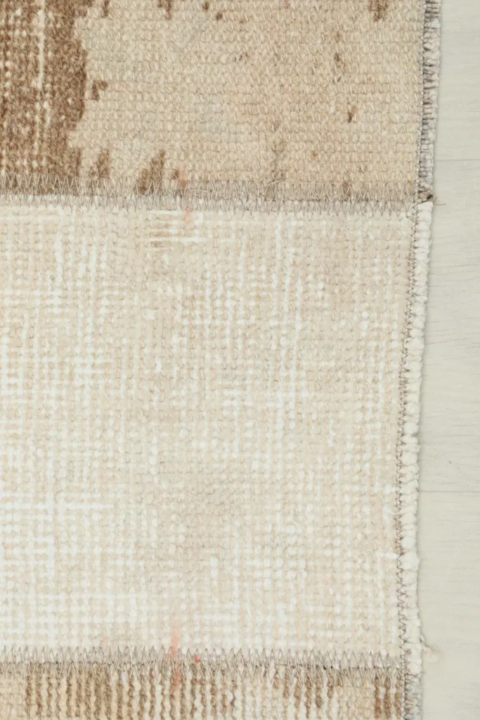 Close-up of the rug's edge, showing the cotton foundation and the finish of the hand-knotted wool pile.