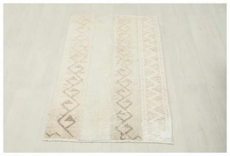 Full top view of the 1'11" x 3'8" vintage beige and tan geometric rug on a white background.