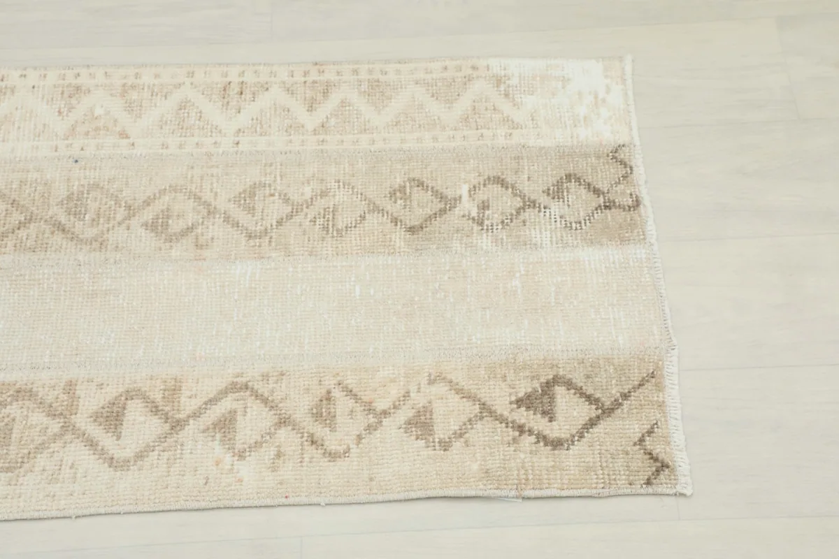 Close-up detail of the beige and tan geometric patterns along one side of the rug.