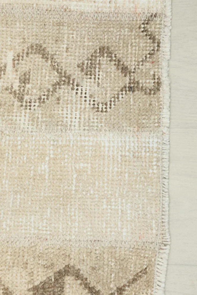 View of the finished edge of the rug, showing the hand-knotted construction and fringe detail.