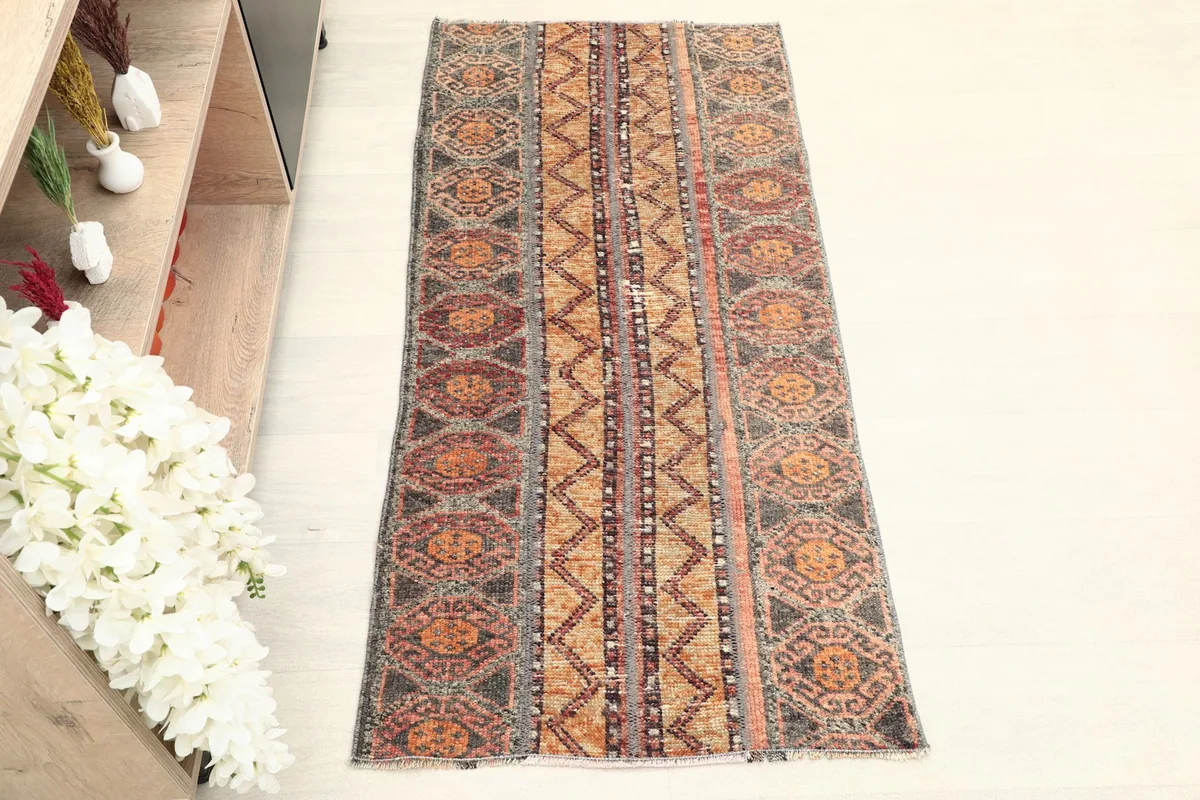 Straight overhead view of the full hand-knotted vintage rug, highlighting its orange and gray patterns.