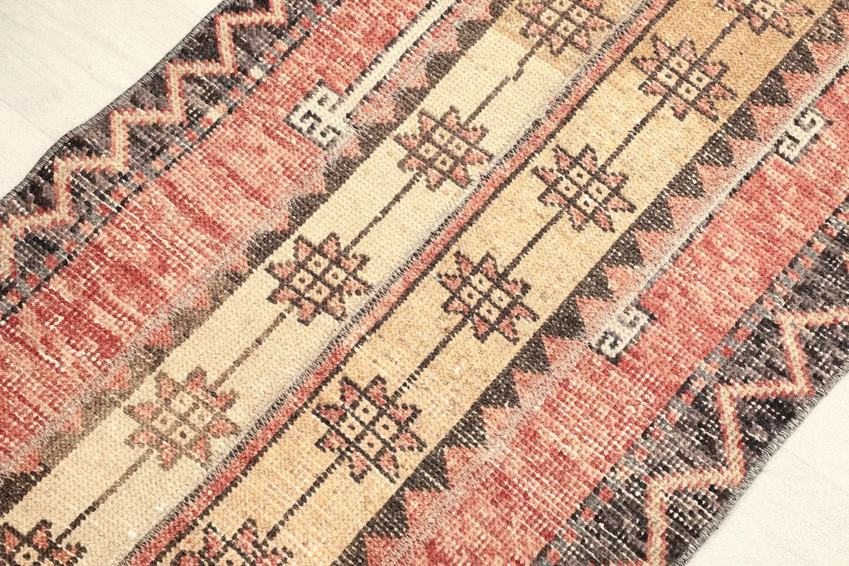 Angled view highlighting the textured wool pile and the intricate geometric motifs.