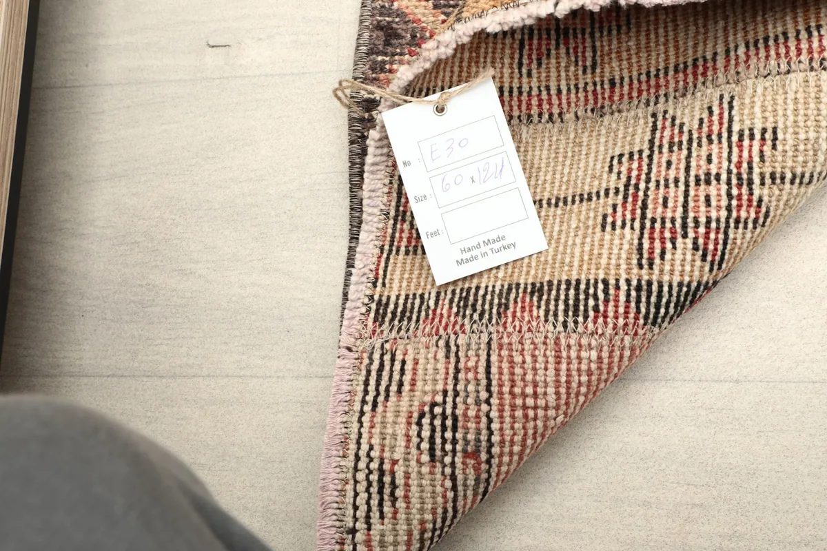 View of the rug's reverse side, revealing the cotton foundation and the product tag.