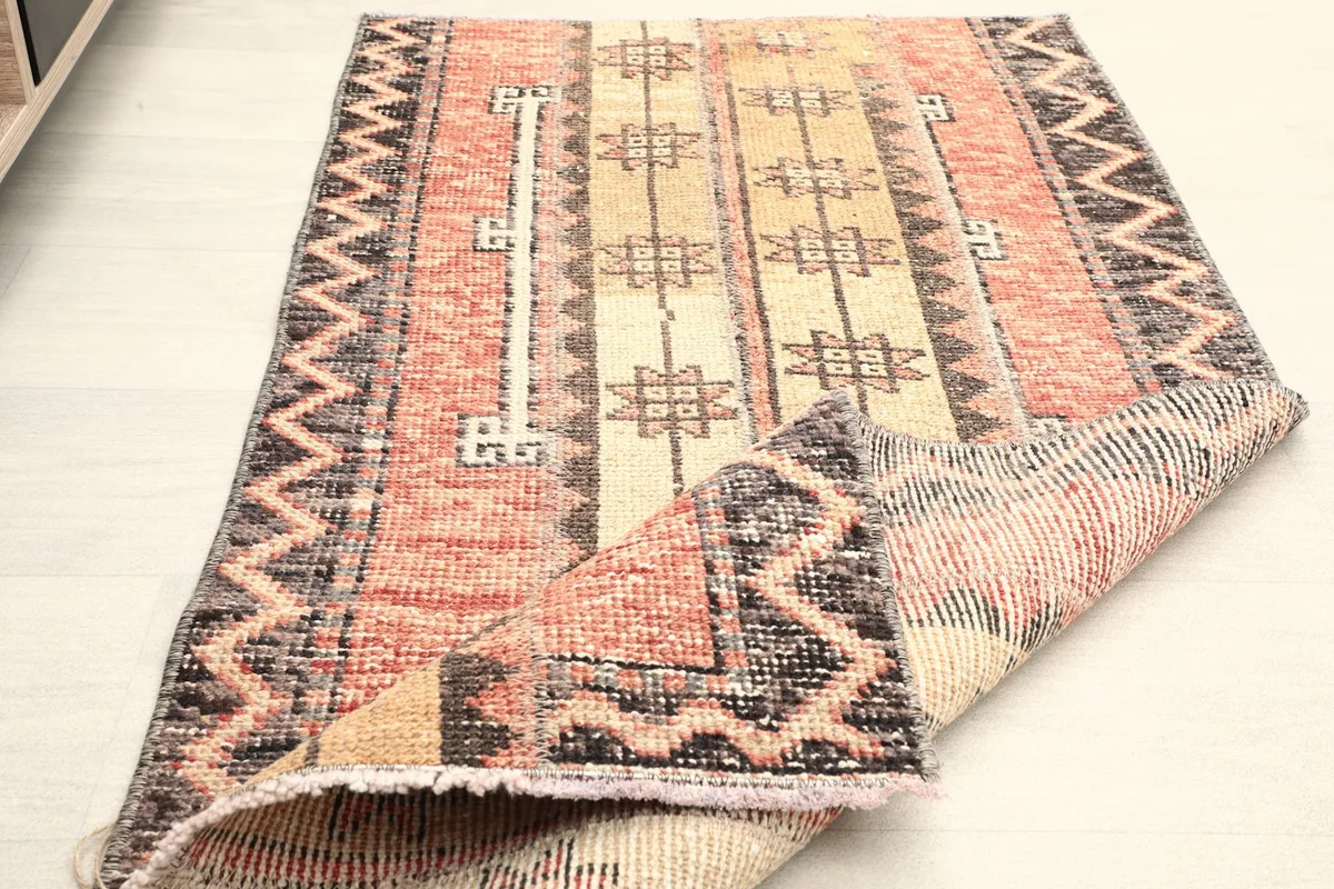View of the rug folded to show the thickness and the overall design from an elevated angle.