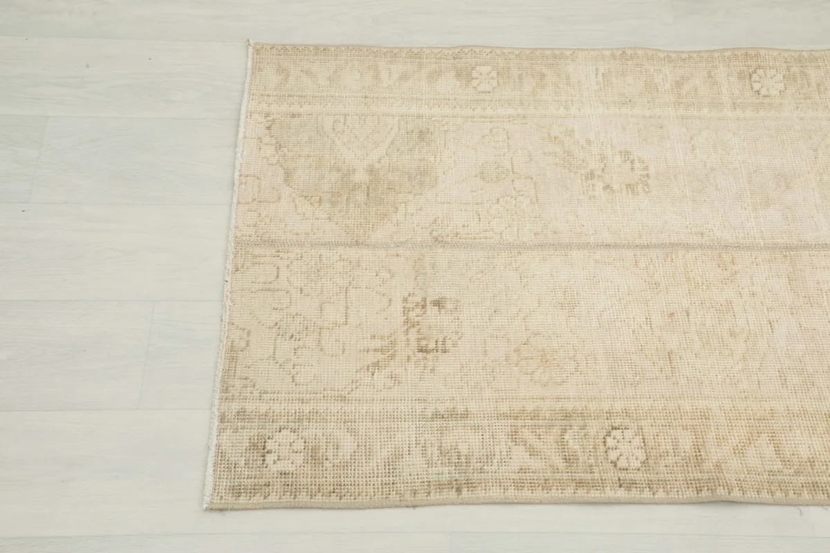 Close-up view of the top right portion of the rug, revealing faded patterns and texture.