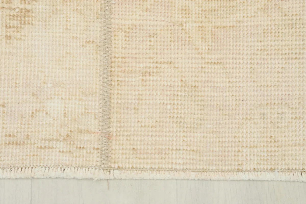 View of the rug's back, showing the cotton foundation and tight knotting from the reverse side.