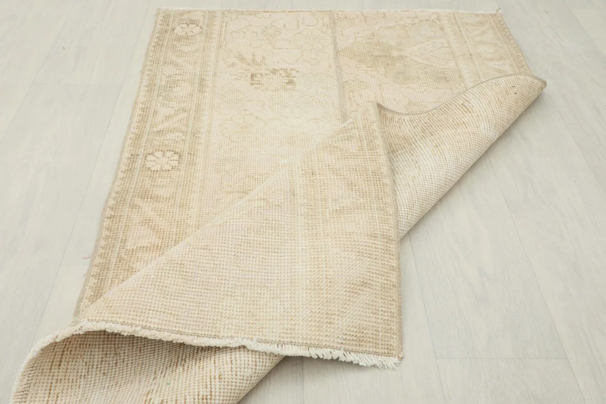 Rug partially folded, showing the flexibility and thickness of the vintage hand-knotted material.