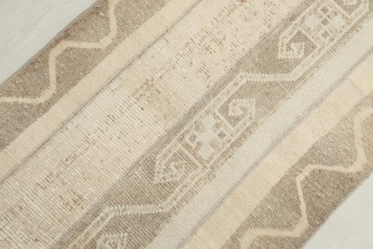 Diagonal close-up showing the varied beige and cream tones and geometric designs
