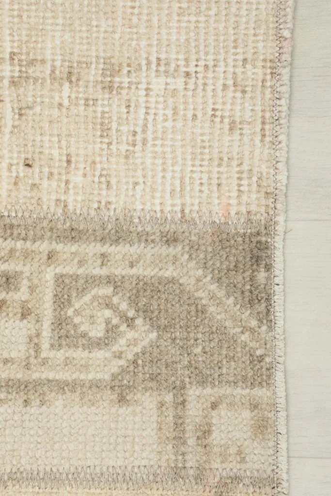 Close-up of the short edge and side finishing of the vintage hand-knotted rug
