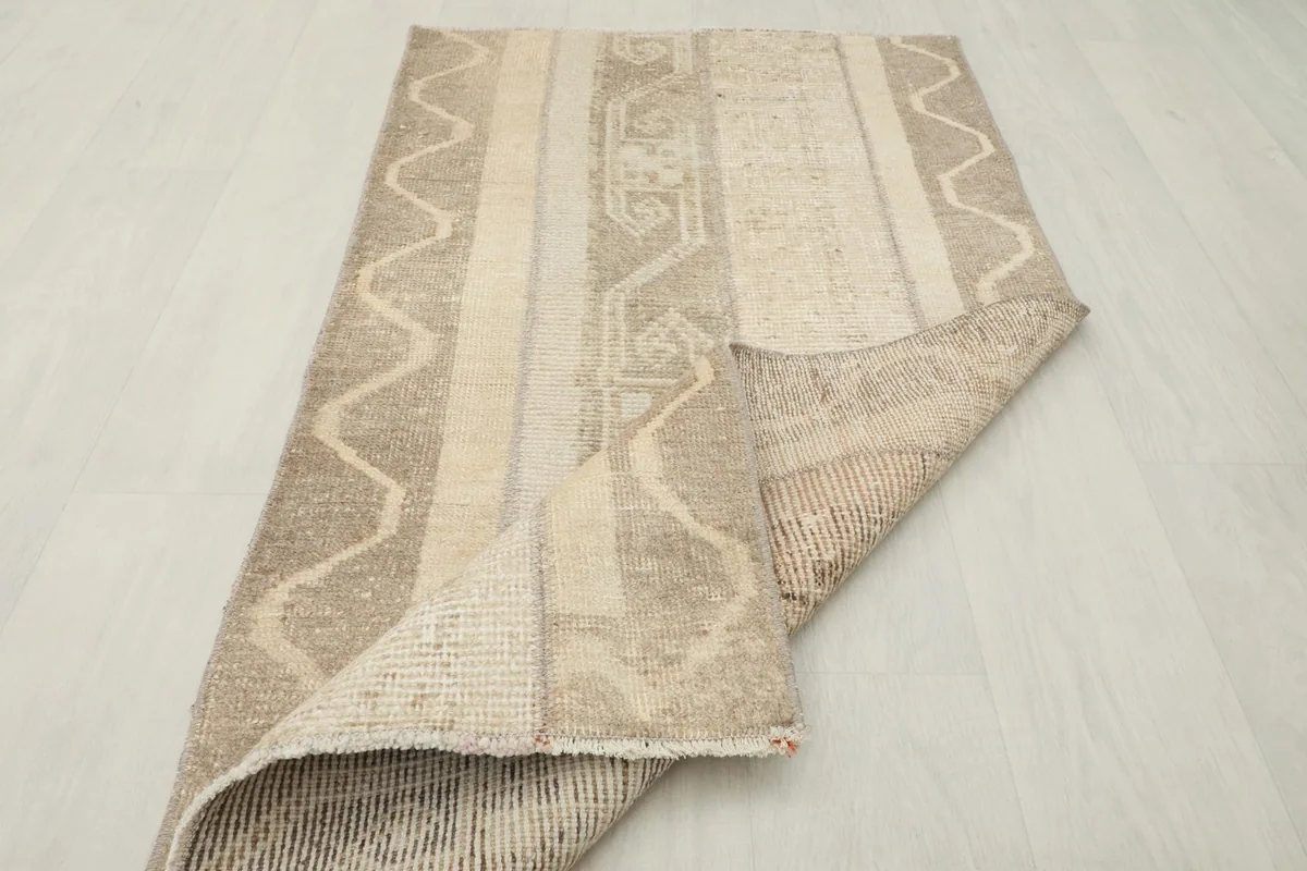 Partial view of the rug's back, showing the hand-knotted construction and foundation