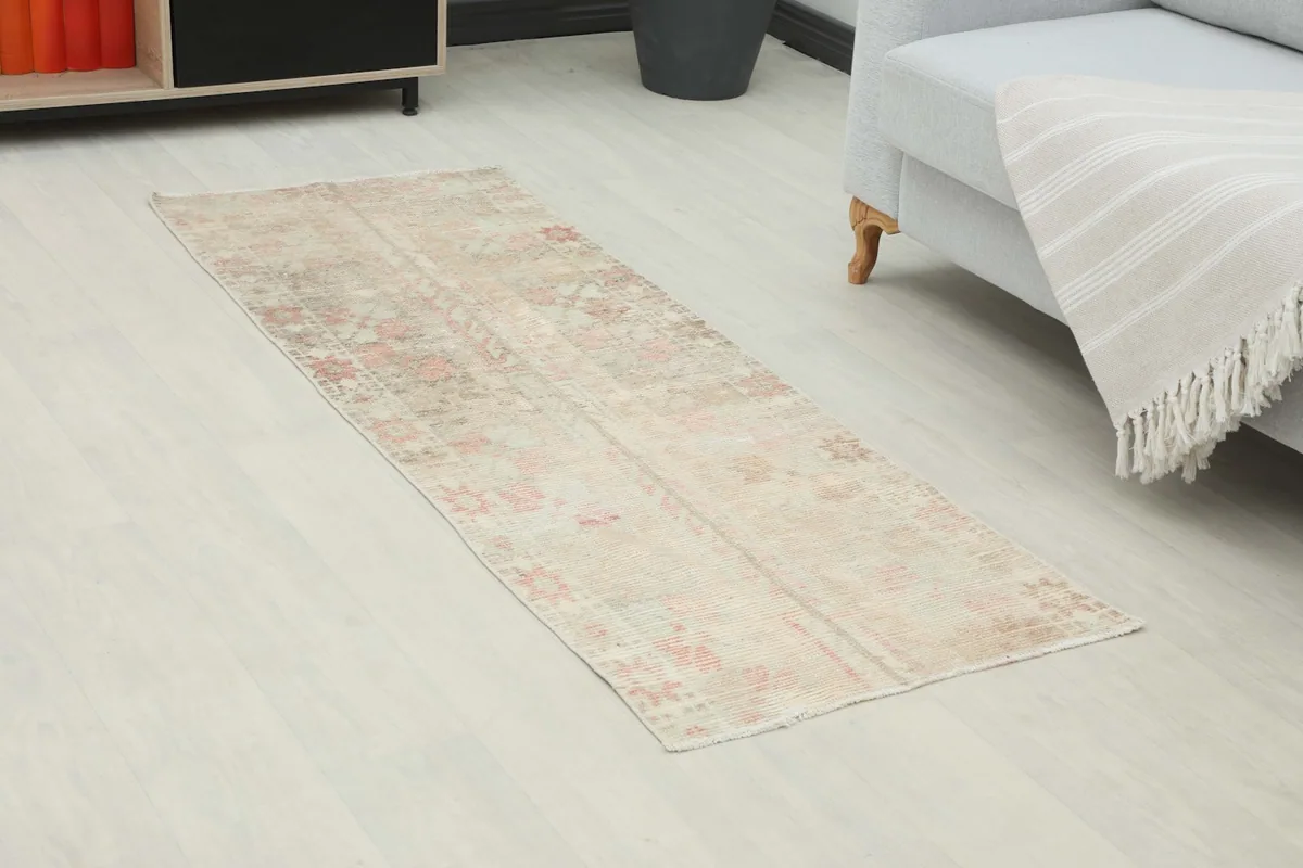 Angled view of the soft rose and beige runner rug on a light floor