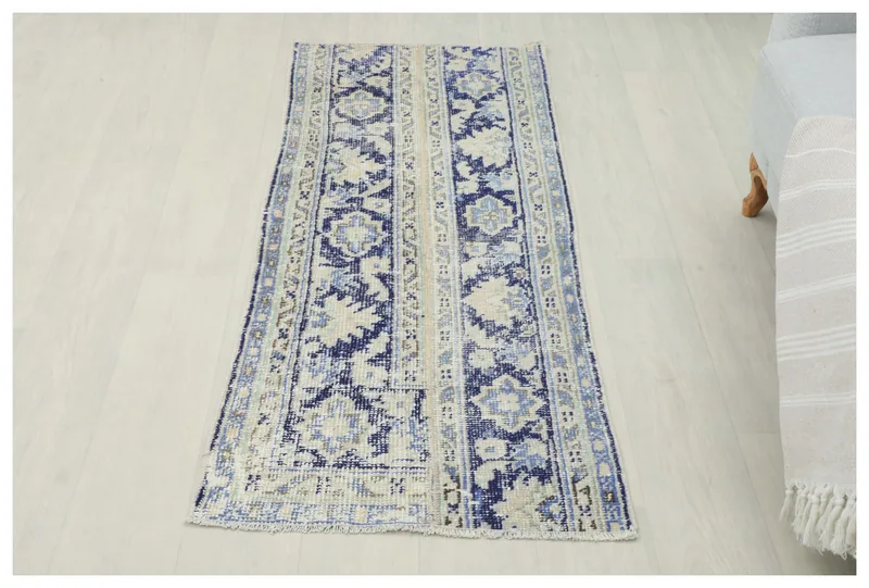 Top view of the 2'1" x 4'11" blue and ivory vintage Anatolian runner rug on a white background.