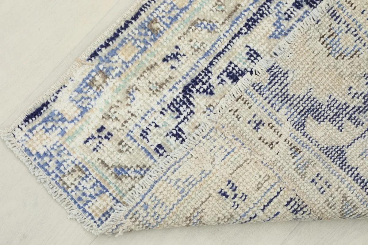 View of the underside of the rug, revealing the cotton foundation and knotting structure.