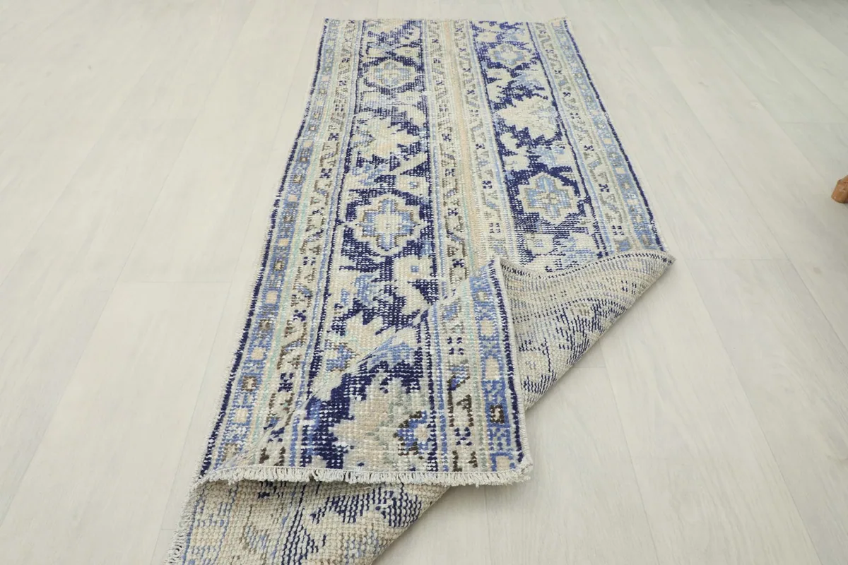 The rug partially rolled, showcasing its flexibility and the consistent pattern from top to bottom.