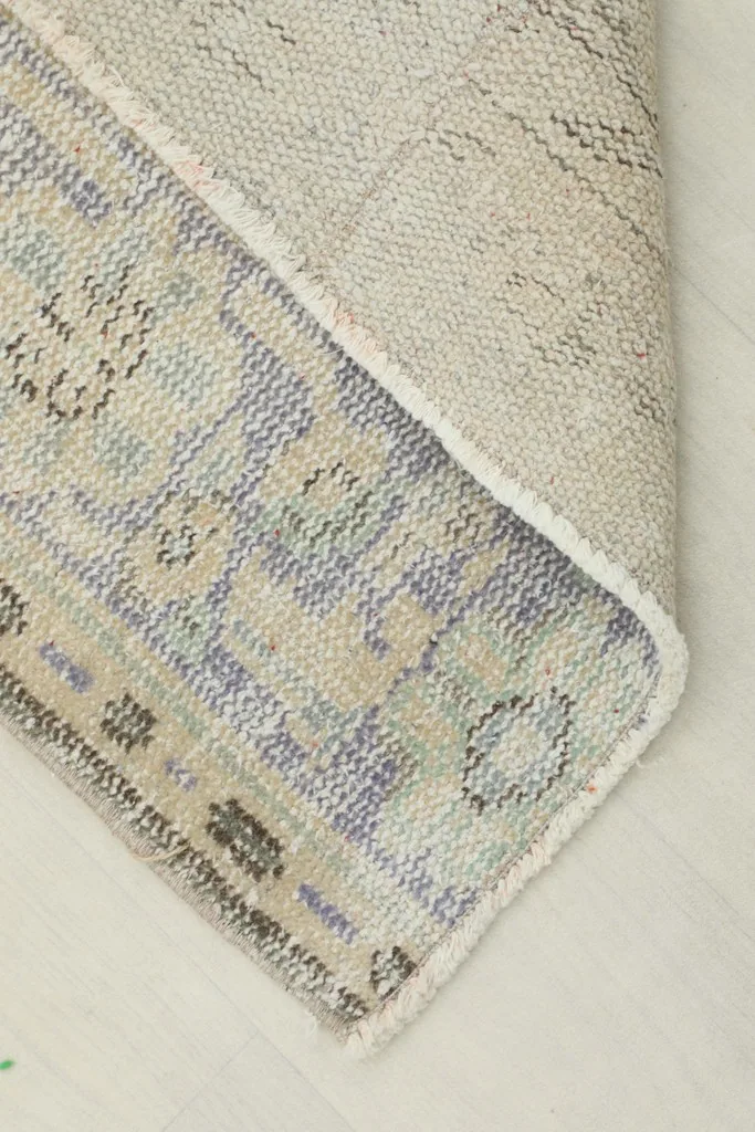 Corner of the runner folded to show the cotton foundation and reverse side of the hand-knotting.
