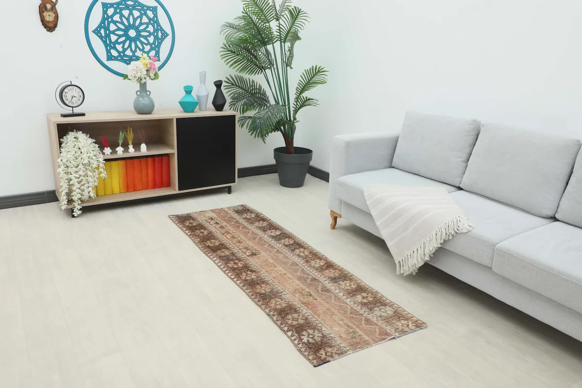 Vintage Anatolian rug placed in a living room setting with a gray sofa