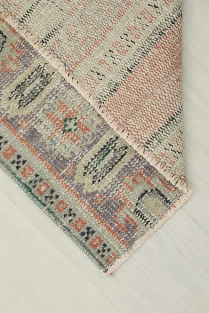 Corner view showing the reverse side of the hand-knotted rug and its cotton foundation