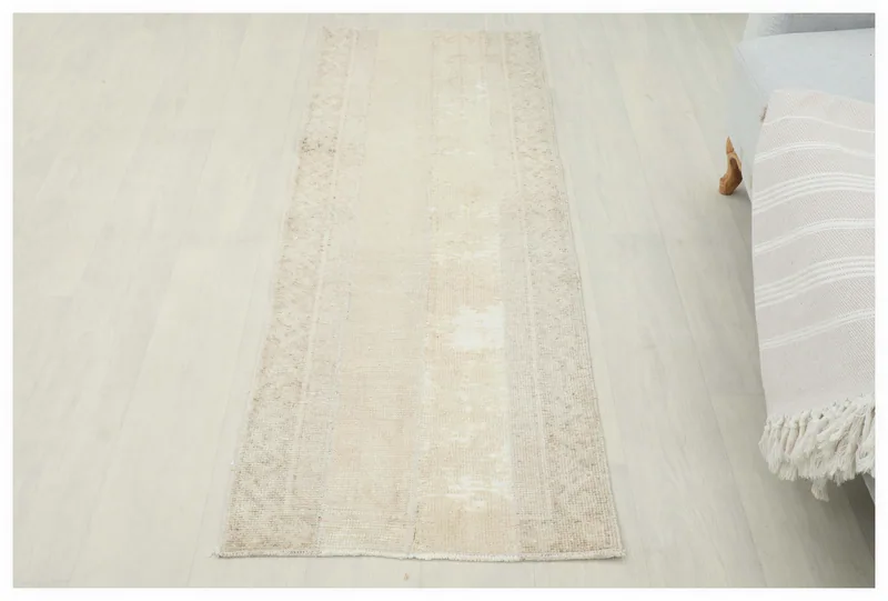 Full top view of the 2x6 vintage tan geometric runner rug on a light floor.