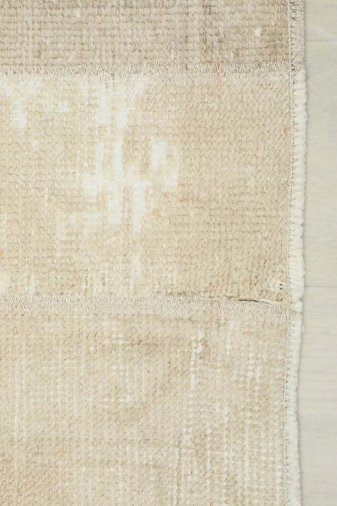 Close-up of the rug's edge, illustrating the hand-finished details and cotton foundation.