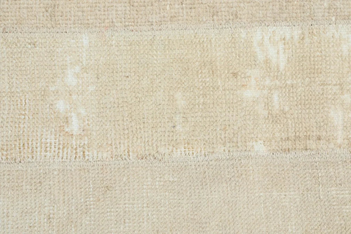 Overhead close-up of the low wool pile, showing areas of wear and original texture.