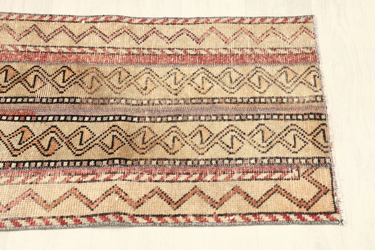 Close-up of the other end of the rug, detailing the striped and zig-zag patterns