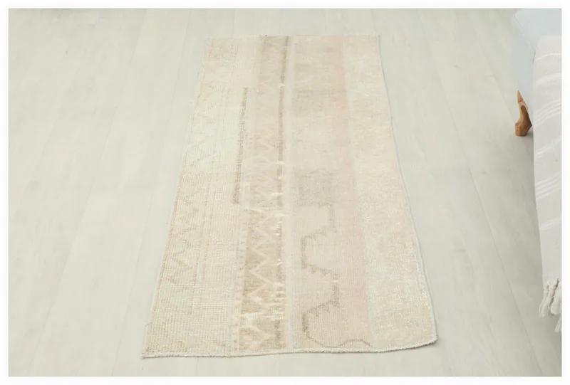 Full overhead view of the beige and rose geometric vintage Anatolian rug on a white background