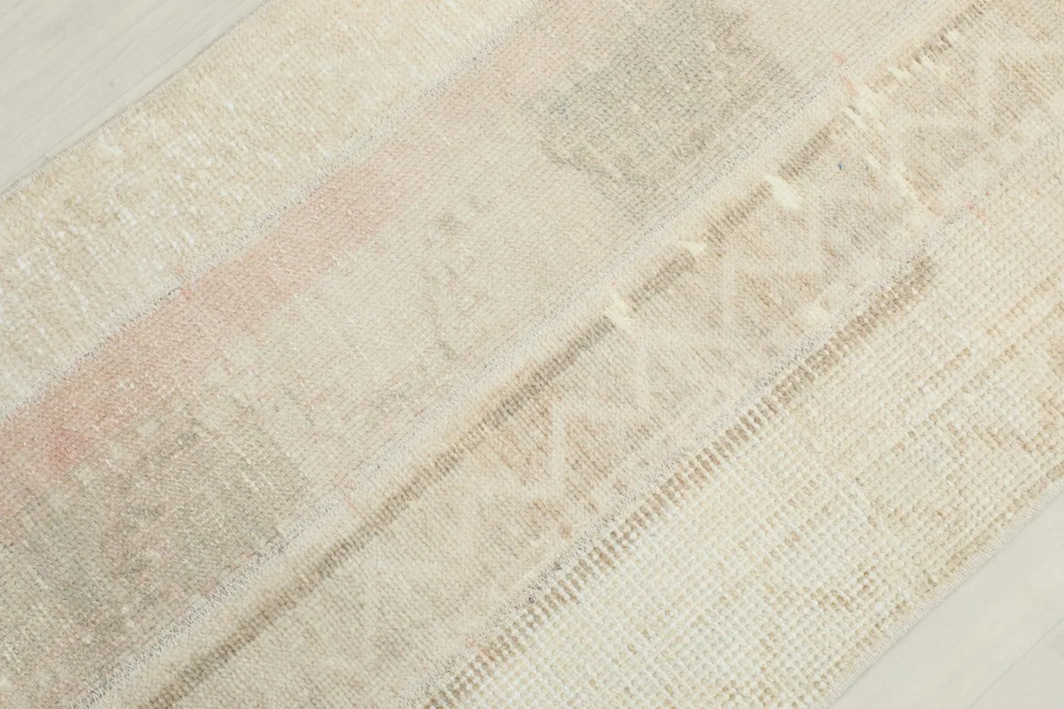 Detailed view of the wool pile and intricate geometric motifs on the vintage rug