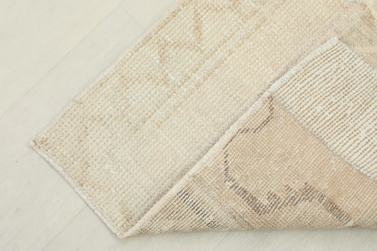 Corner of the vintage rug folded to show the thickness and flexibility of the material