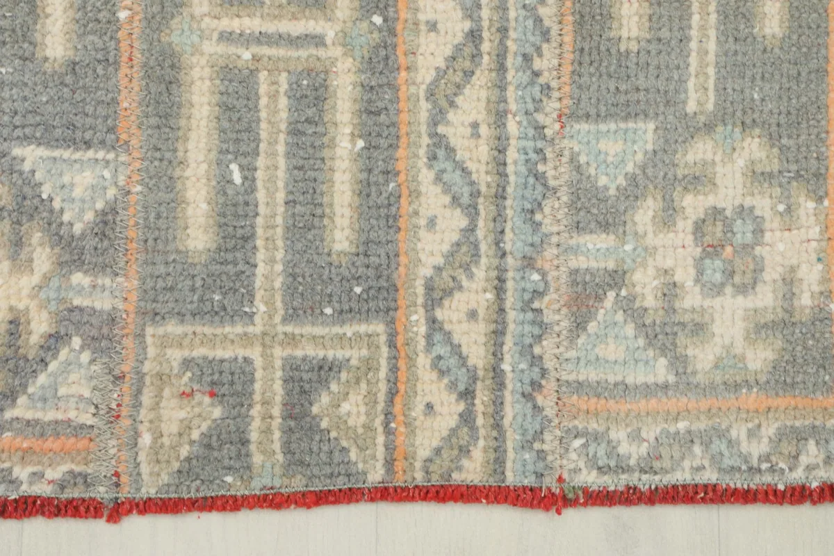 Close-up of the rug's edge, showing the red selvage and pattern details