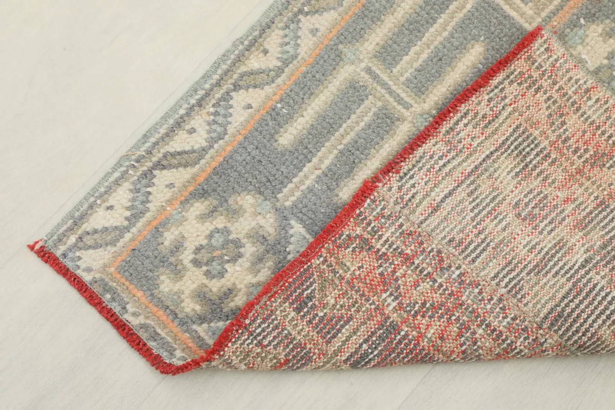 Corner of the runner folded to show the hand-knotted back and cotton foundation