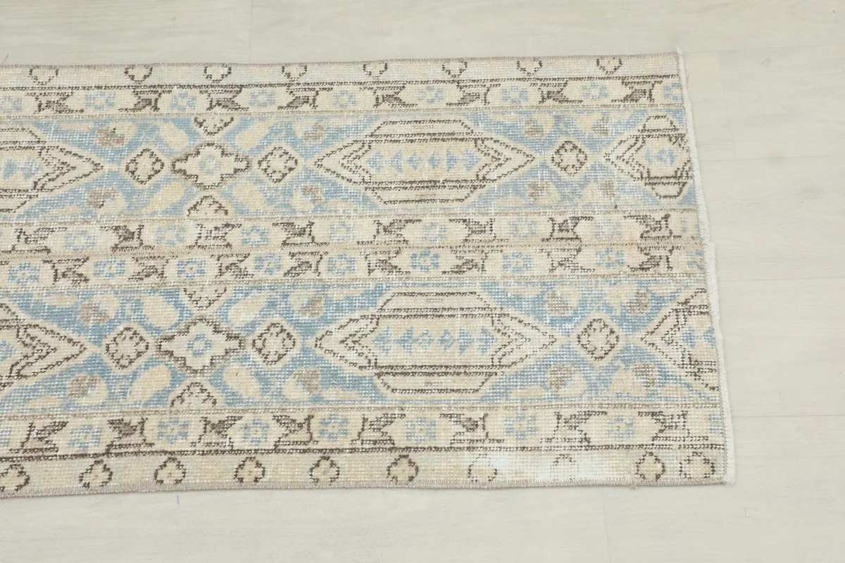 Close-up of the geometric patterns and blue and beige colors at one end of the runner.