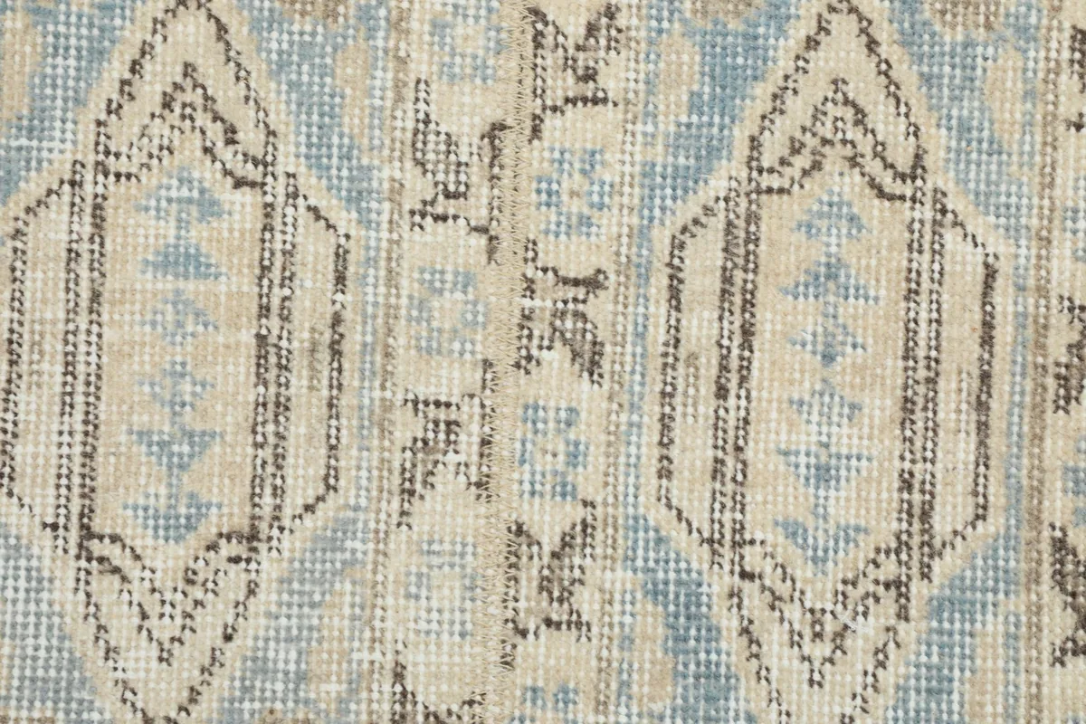 Tight close-up of the low wool pile and intricate geometric design of the vintage runner.