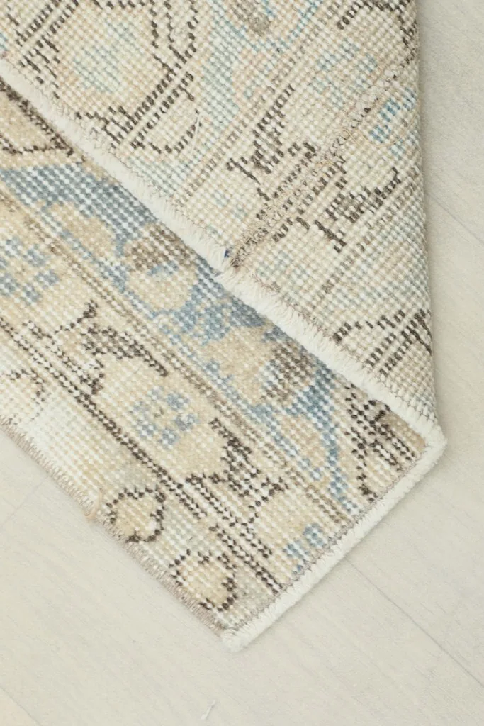 Corner of the runner folded to show the cotton foundation and hand-knotted construction.