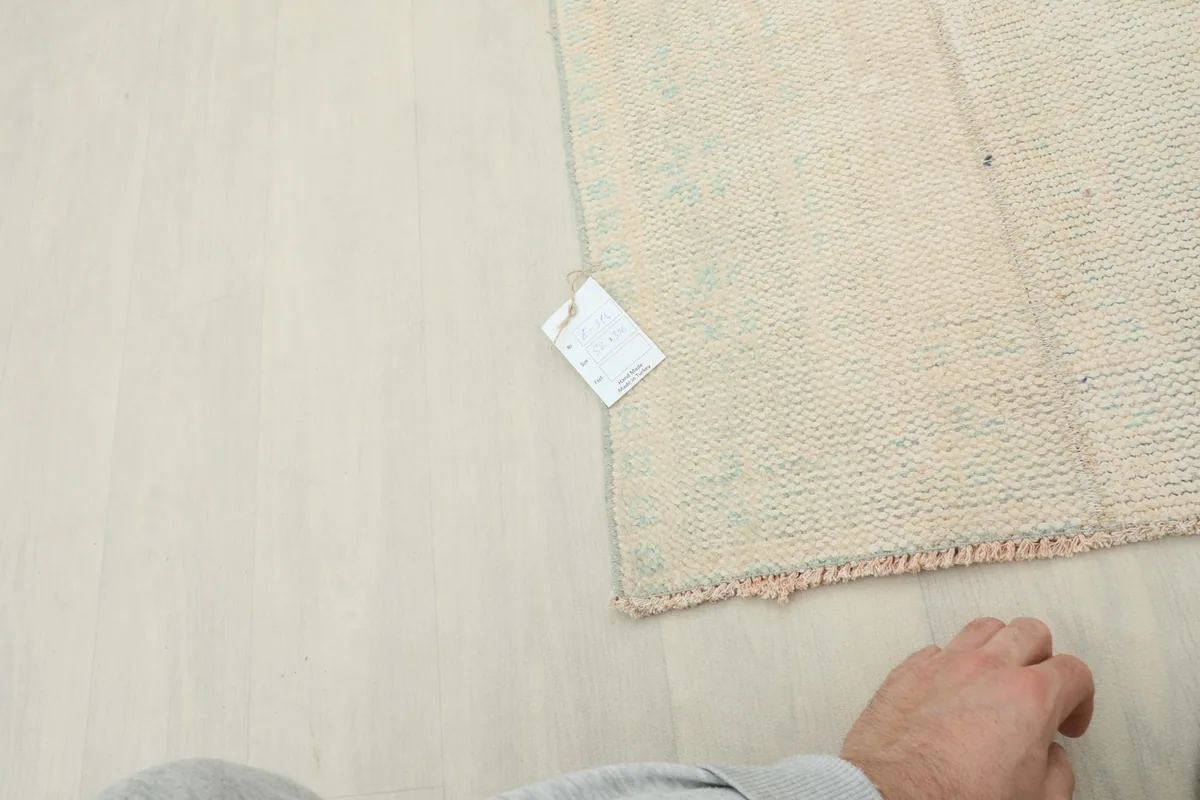 Close-up of the rug's label on the back, with a hand visible for scale.