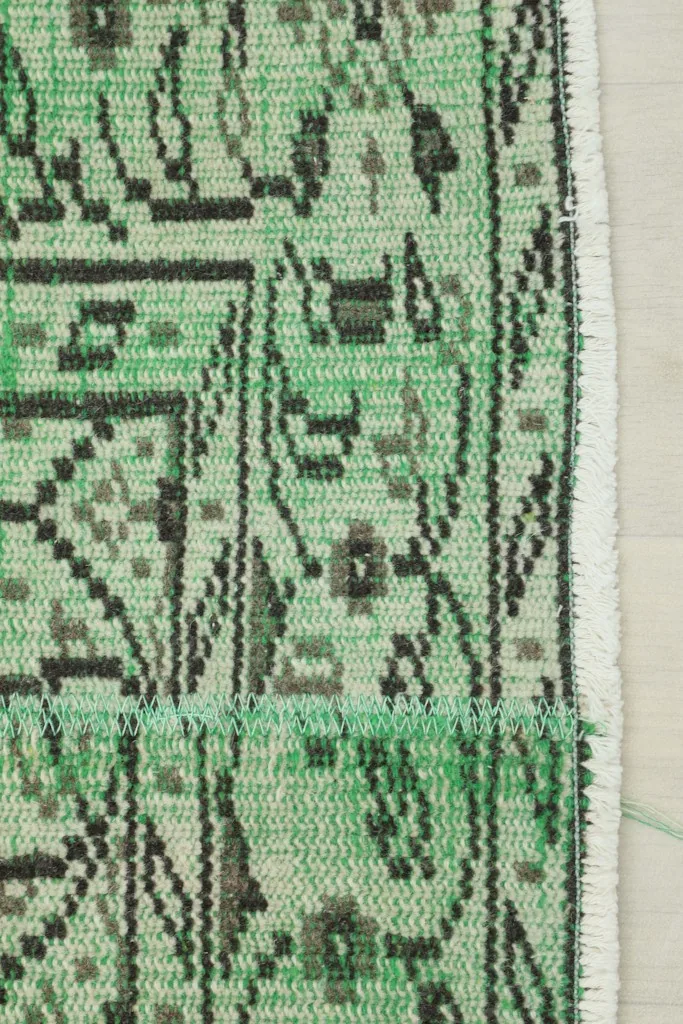 Close-up of the rug's border and fringe, showing the hand-finishing