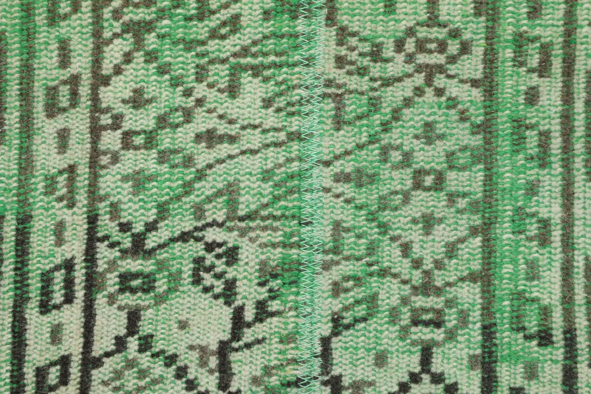 Detailed view of the low wool pile and the hand-knotted texture of the vintage rug