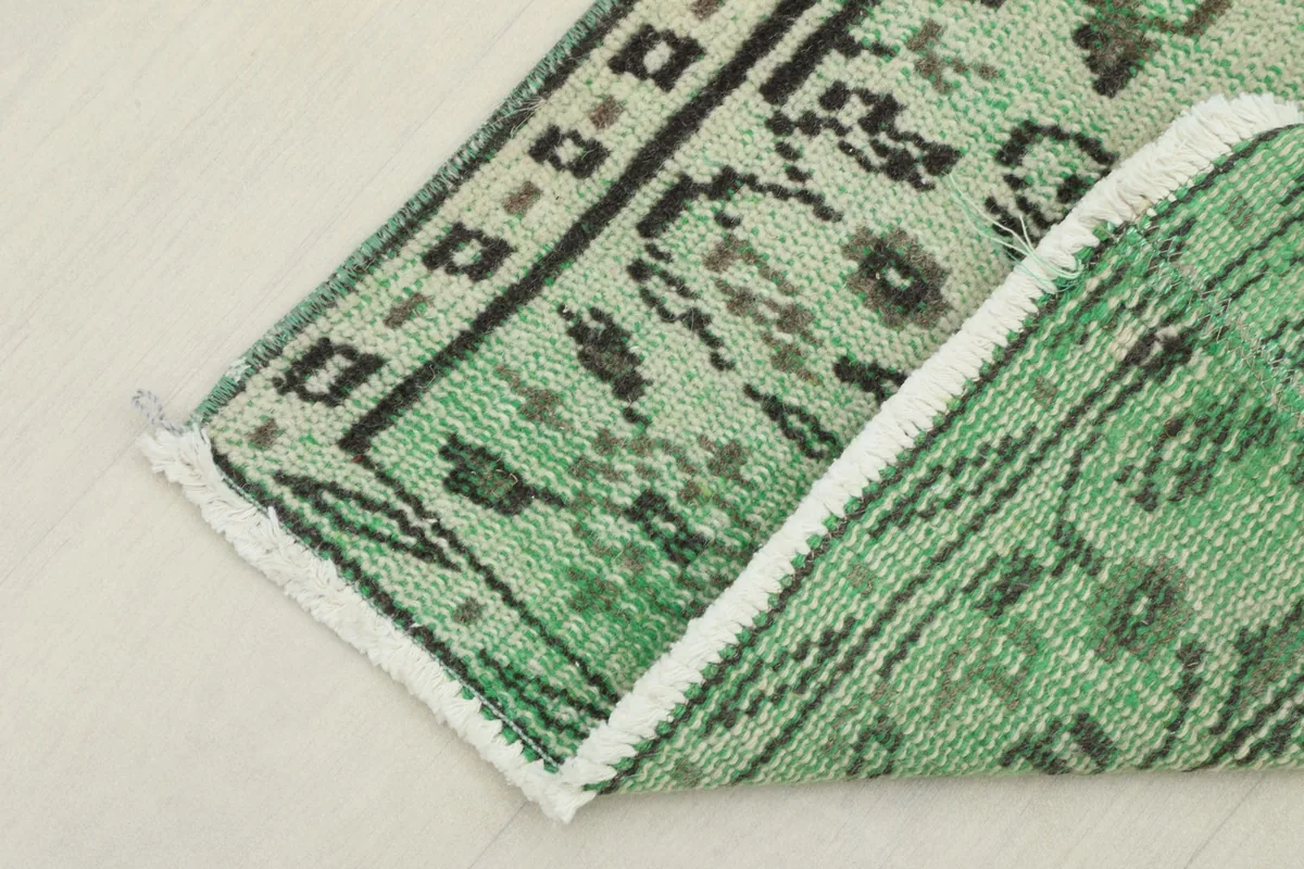 View of the rug folded to show the back and the texture of the wool pile