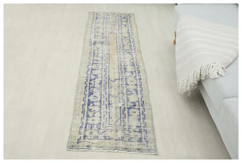 Full top view of the beige and blue geometric vintage Anatolian runner rug on a white background.