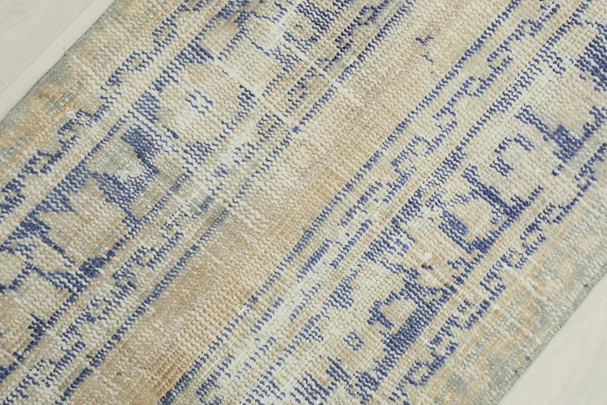 Detailed view of the low wool pile, showing the texture and faded blue and beige colors.