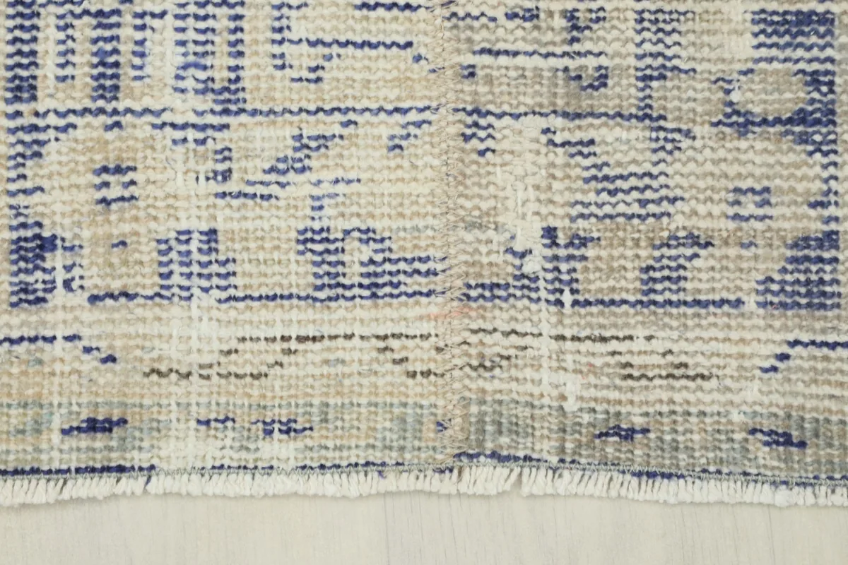 Close-up of the short, natural cotton fringes at the end of the vintage runner rug.