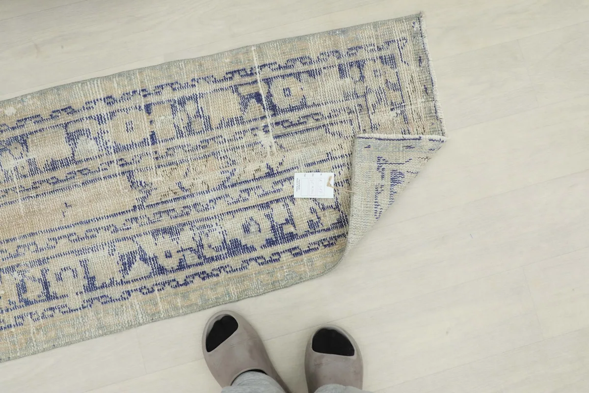 Overhead view of the rug with feet nearby, demonstrating its length and scale.