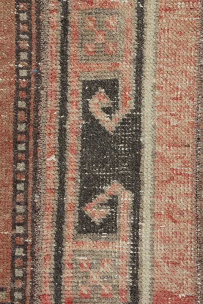 Vertical close-up of the rug's central design elements, showcasing the hand-knotted wool pile.